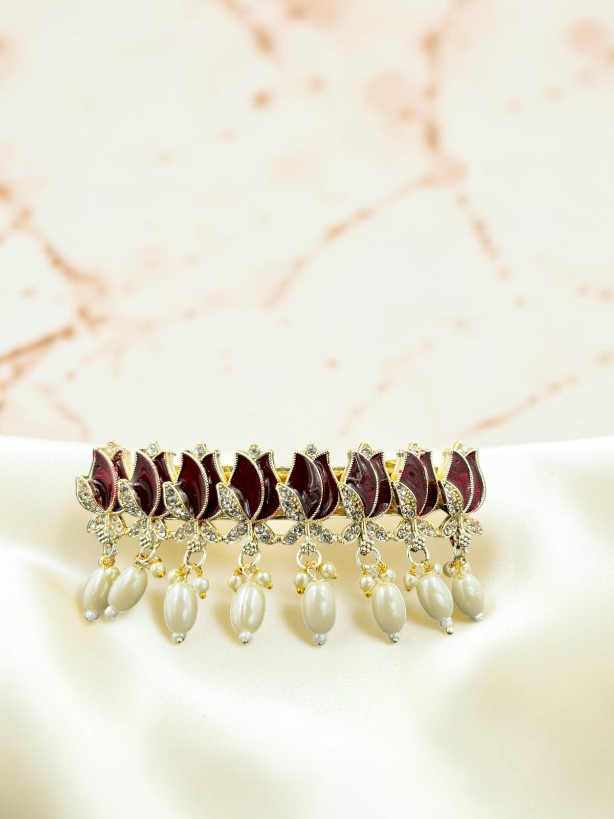 SHE BEAUTY AD Tulip Meenakari pearl barrette featuring maroon enamel floral motifs and dangling white pearl accents.