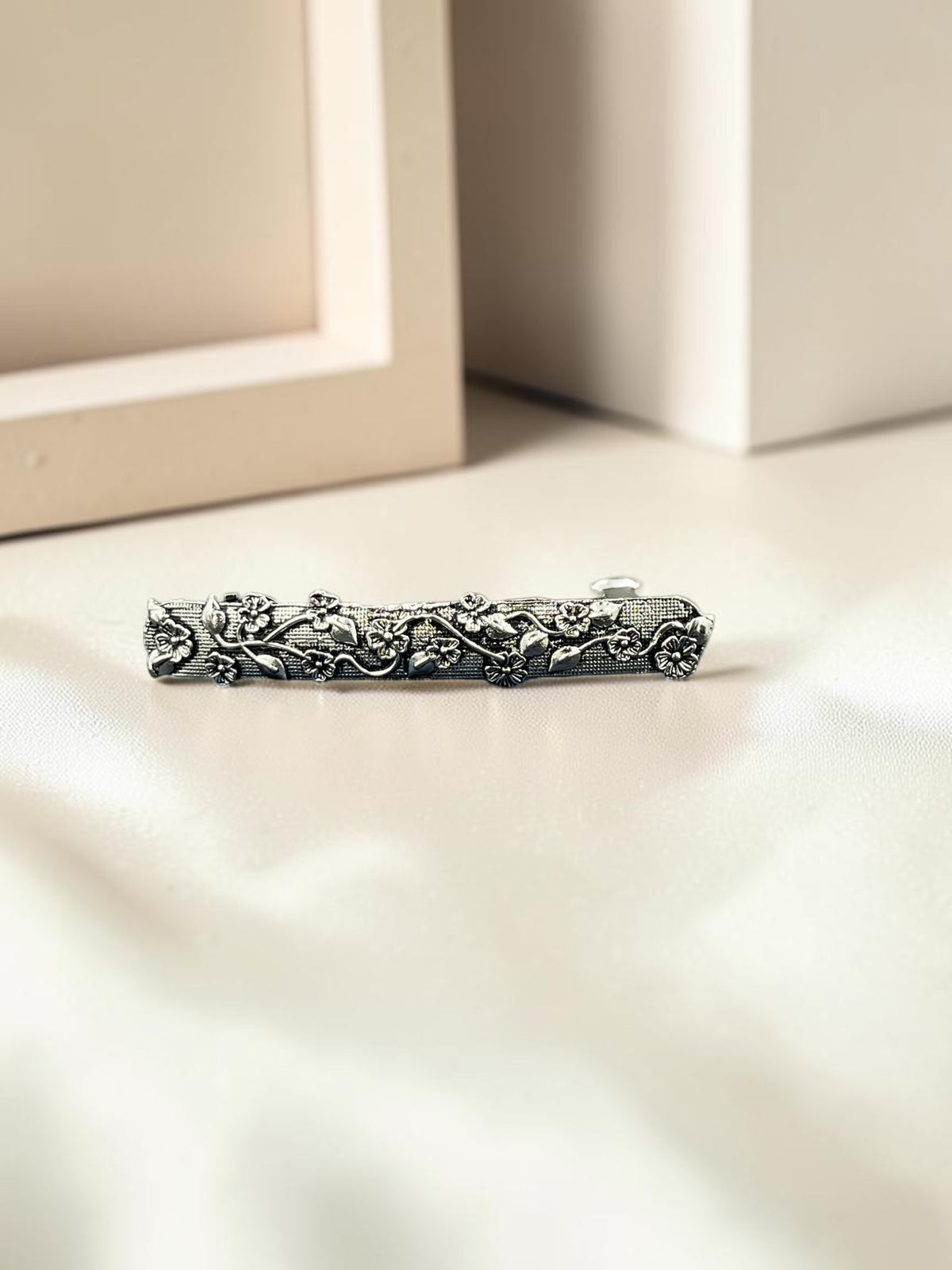 SHE BEAUTY vine vintage metallic barrette with intricate floral and leaf engravings in a silver-toned finish.