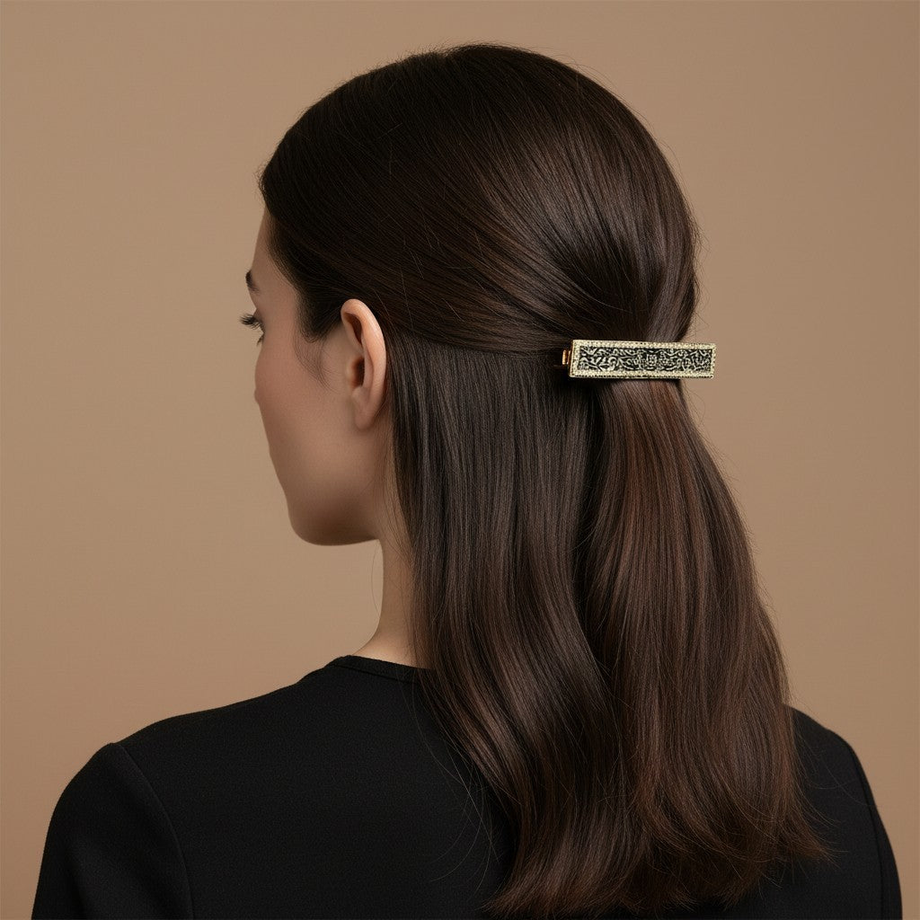 SHE BEAUTY vintage metallic barrette with intricate lace-inspired detailing worn in a woman's dark hair