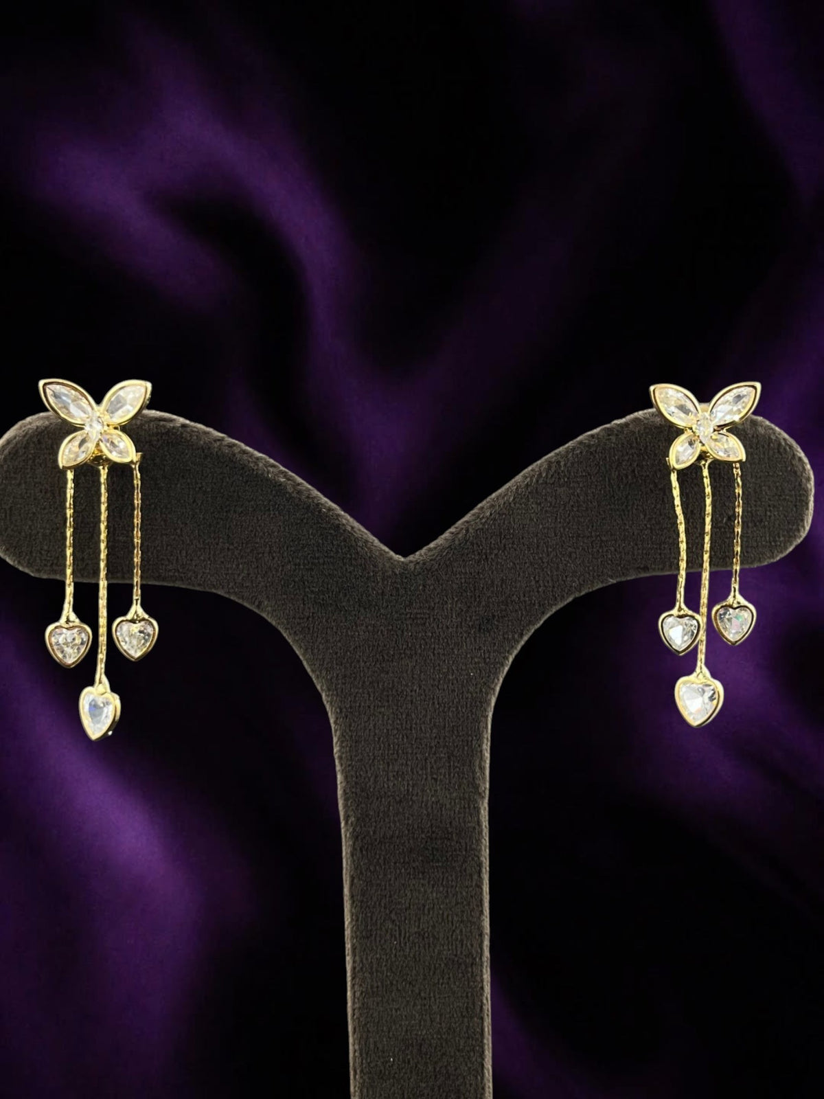 SHE BEAUTY Wing Petals gold-tone drop earrings featuring butterfly motifs and dangling heart-shaped crystal charms.