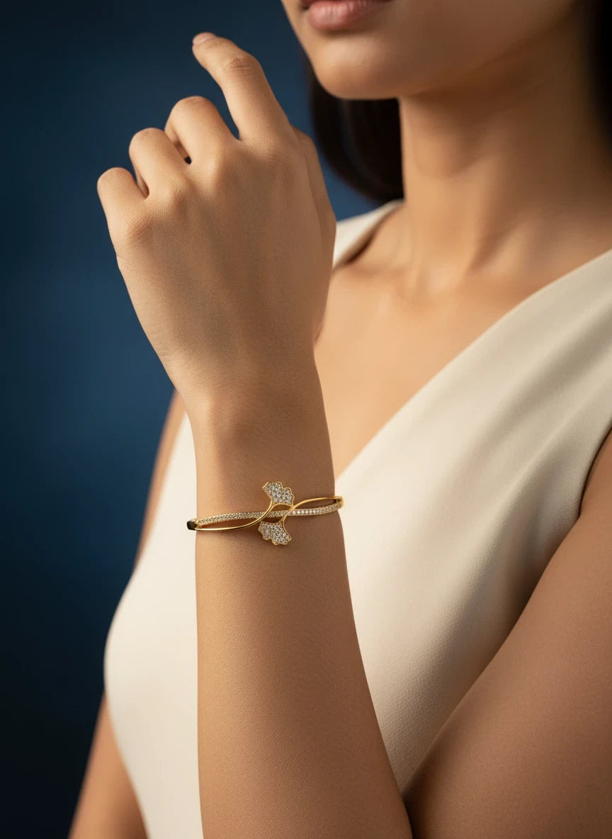 SHE BEAUTY gold-toned anti-tarnish bracelet featuring a delicate zirconia floral design on a woman's wrist