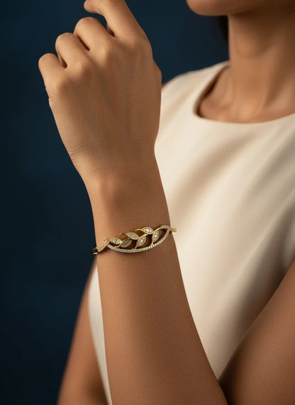 SHE BEAUTY gold-toned anti-tarnish bracelet featuring a delicate leaf design with sparkling zirconia stones.