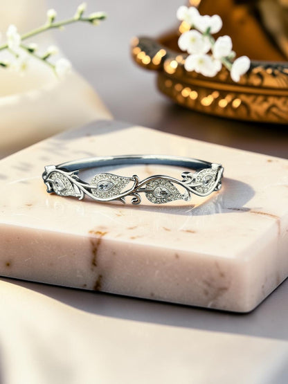 SHE BEAUTY anti-tarnish silver bracelet featuring intricate leaf-shaped zirconia stones on a marble display stand.