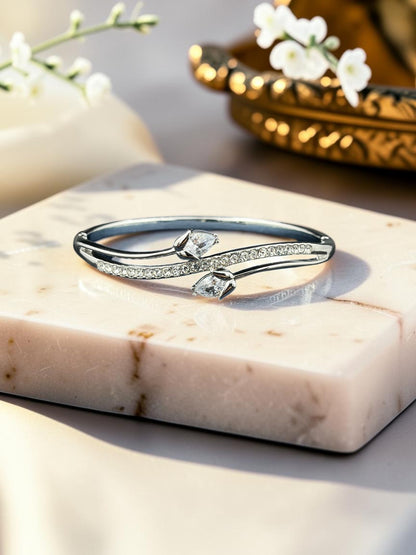 SHE BEAUTY anti-tarnish silver bracelet featuring a curved design with sparkling zirconia stones on a marble block.